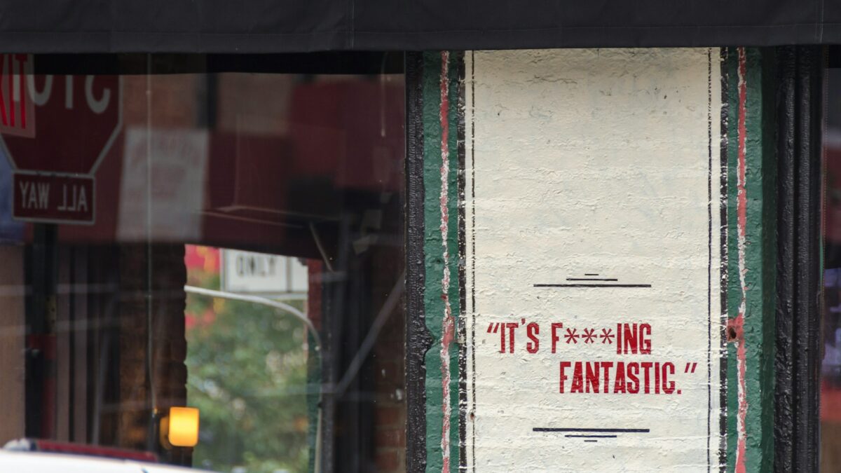 white and red signage on brick wall