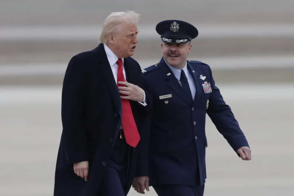 President Donald Trump speaks with Col. Paul Pawluk, Vice Commander of the 89th Airlift Wing, as he walks from Marine One before boarding Air Force One, Friday, March 14, 2025, at Joint Base Andrews, Md.