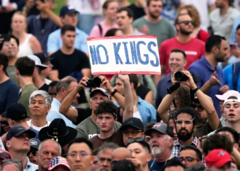 A person holds a sign reading