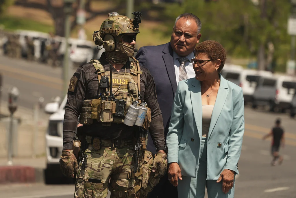 Los Angeles Mayor Karen Bass walks with a federal agent at MacArthur Park Monday, July 7, 2025, in Los Angeles.