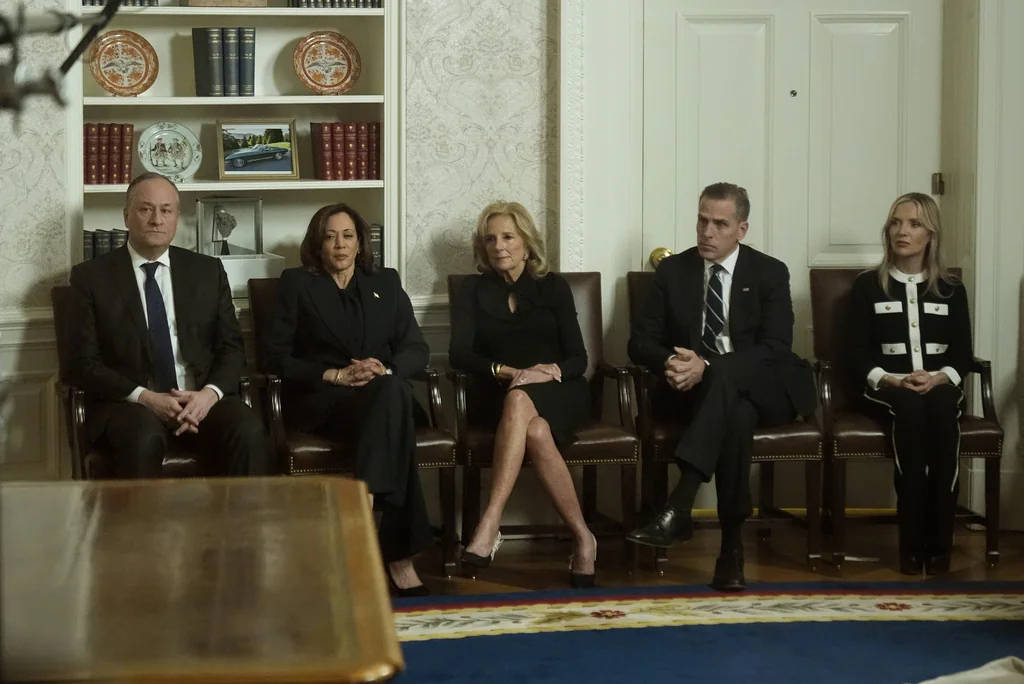 As seen through a window from the Colonnade outside the Oval Office, second gentleman Doug Emhoff, Vice President Kamala Harris, first lady Jill Biden, Hunter Biden and Melissa Cohen Biden watch as President Joe Biden speaks during his farewell address at the White House in Washington, Wednesday, Jan. 15, 2025.