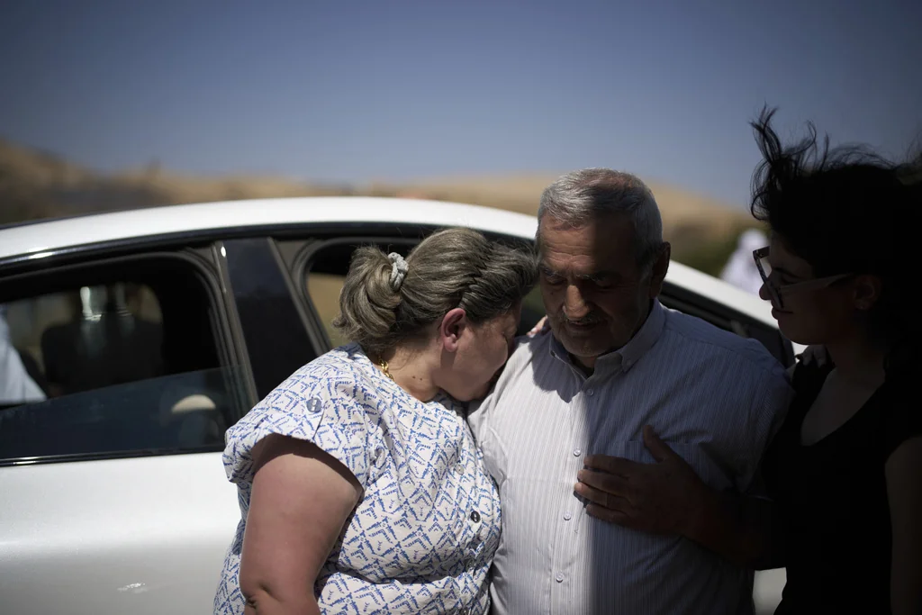 Syrian Druze, Fares Abu Zaid, 80, center, says goodbye to Druze relatives from Israel before crossing back into Syria at the Israeli-Syrian border, in the Israeli-controlled Golan Heights town of Majdal Shams, Thursday, July 17, 2025. 