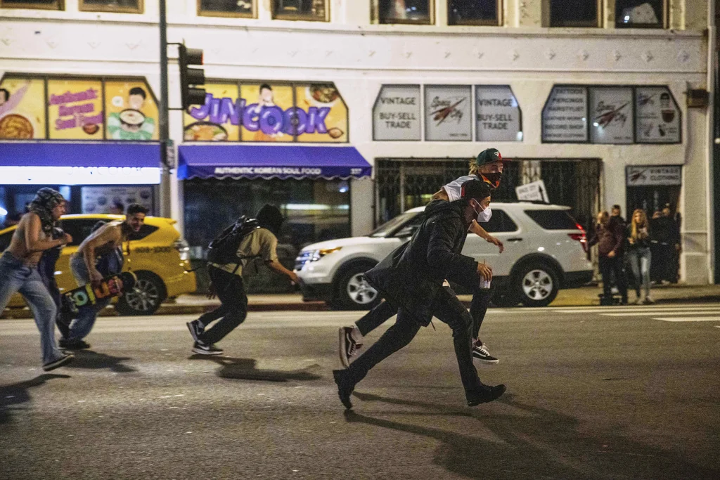 Protesters run to avoid being kettled by police during protests over the Trump administration's immigration raids in Los Angeles, Monday, June 9, 2025. 