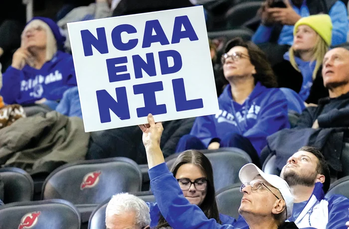 A fan holds a sign about name, image, and likeness during a college basketball game between Seton Hall University and DePaul University in Newark, New Jersey, Jan. 8, 2025. (Porter Binks/Getty Images)