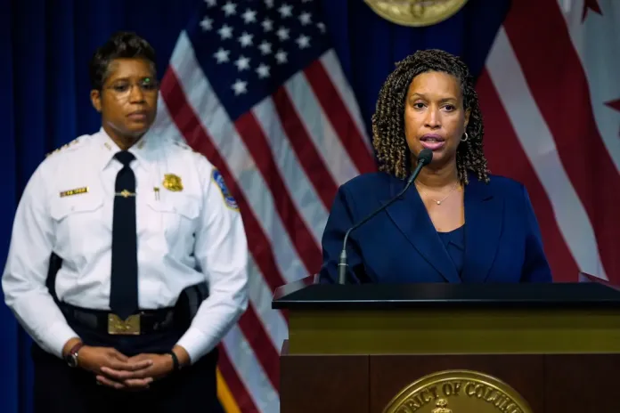 Washington Mayor Muriel Bowser speaks as Metropolitan Police Department Chief Pamela Smith listens during a news conference on President Donald Trump's plan to place Washington police under federal control and deploy National guard troops to Washington, Monday, Aug. 11, 2025, in Washington. (AP Photo/Julia Demaree Nikhinson)
