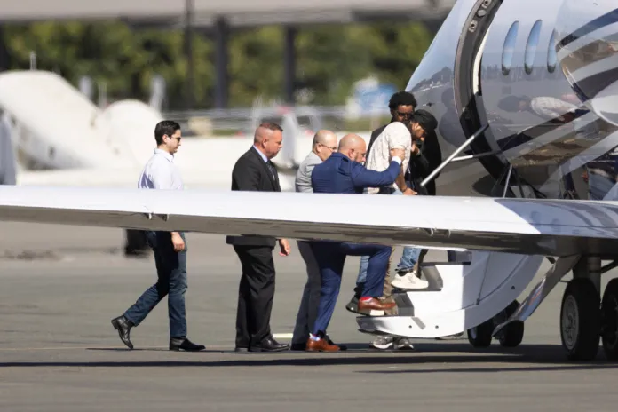 Harjinder Singh is escorted onto an airplane by Florida Lt. Gov. Jay Collins and law enforcement on Thursday, Aug. 21, 2025, in Stockton, Calif. (AP Photo/Benjamin Fanjoy)