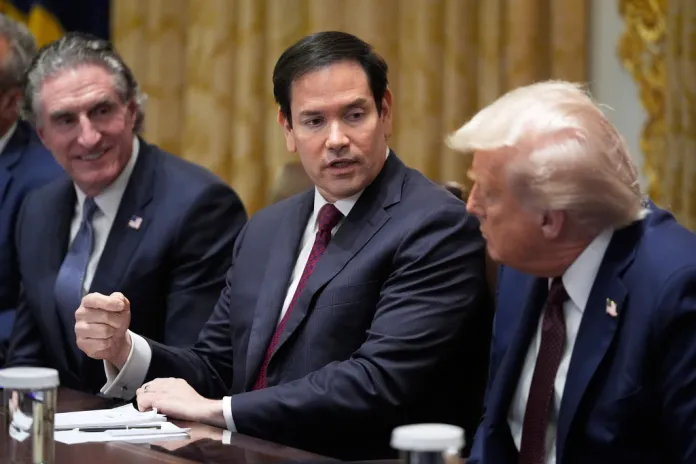 President Donald Trump, right, listens as Secretary of State Marco Rubio speaks during a Cabinet meeting in the White House, Tuesday, Aug. 26, 2025, in Washington. Interior Secretary Doug Burgum looks on.