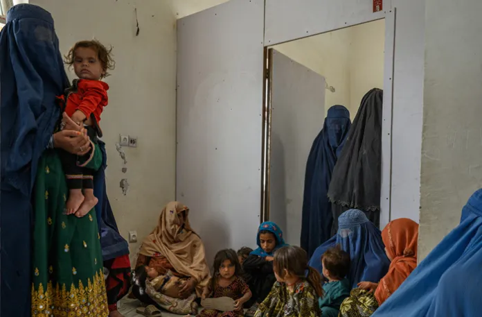 Women wait inside a district hospital on Aug. 26 in Ghazni, Afghanistan. The hospital has struggled to cope with an increase in patients following US funding cuts which led to the closure of other health facilities in the area.  (Elise Blanchard/Getty Images)