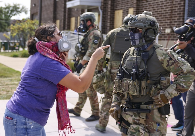 A protester confronts an Immigration and Customs Enforcement officer outside an ICE facility.