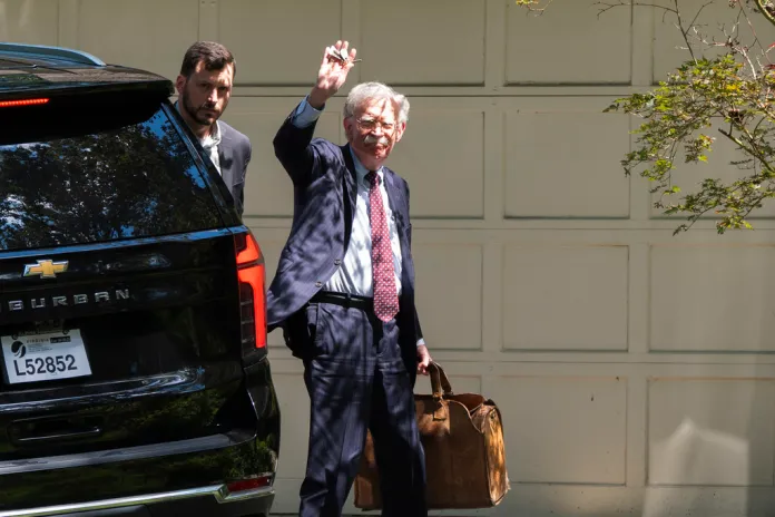 Former national security adviser John Bolton waves as he arrives at his house Friday, Aug. 22, 2025, in Bethesda, Md. 