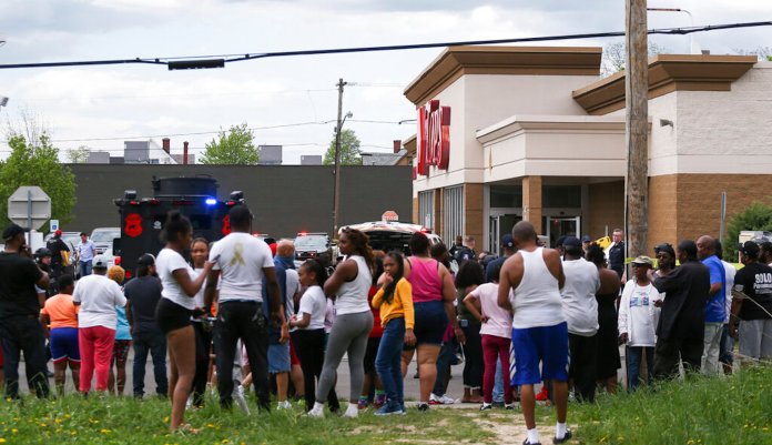 A crowd gathers as police investigate after a shooting at a supermarket on Saturday in Buffalo, New York. Multiple people were shot at the Tops Friendly Market. Police have notified the public that the alleged shooter was in custody.