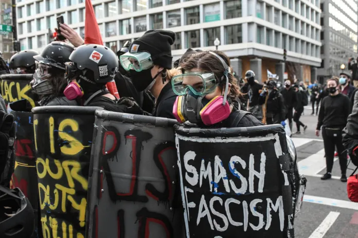 Members of Antifa hold shields during a protest at Black Lives Matter Plaza on December 12, 2020 in Washington, DC. Thousands of protesters who refuse to accept that President-elect Joe Biden won the election are rallying ahead of the electoral college vote to make Trump's 306-to-232 loss official. (Photo by Stephanie Keith/Getty Images)