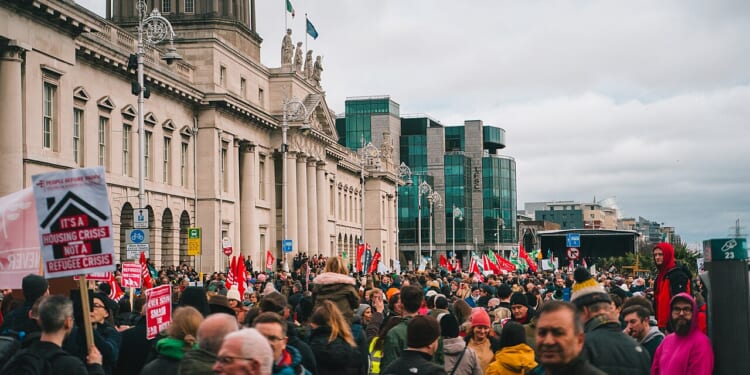 rally outside of building in Ireland with flags