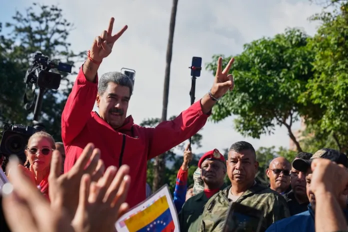 President Nicolas Maduro flashes victory signs during Indigenous Day in Caracas, Venezuela, Sunday, Oct 12, 2025. (AP Photo/Ariana Cubillos)