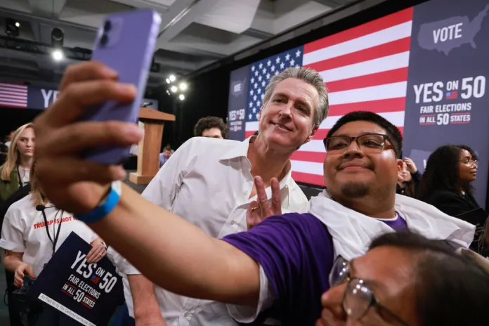Gov. Gavin Newsom (D-CA) meets with attendees during a campaign event on Proposition 50