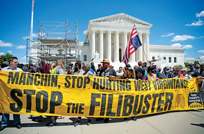Protesters in front of the Supreme Court building in Washington, D.C., call out then-Sen. Joe Manchin (D-WV) for refusing to eliminate the Senate’s filibuster and allow the passage of an elections-reform bill, June 23, 2021. (Caroline Brehman/CQ-Roll Call via Getty Images)