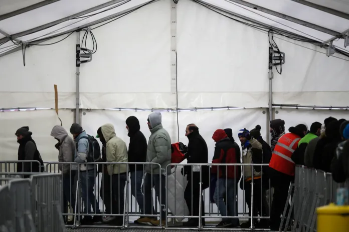 Migrants and refugees line up at a central registration center for refugees and asylum-seekers.