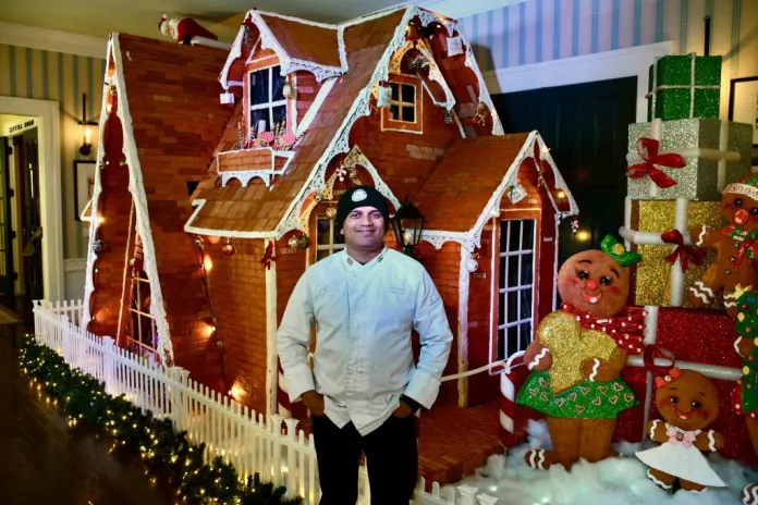 Naik poses with his gingerbread house creation.
