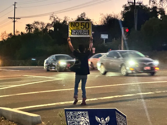 Maria Garcia holds a “No to Prop 50” 