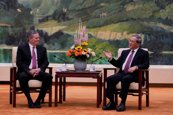 Chinese Premier Li Qiang, right, meets U.S. Senator Steve Daines in the Fujian Room at the Great Hall of the People in Beijing, China, Sunday, March 23, 2025. (AP Photo/Ng Han Guan, Pool)