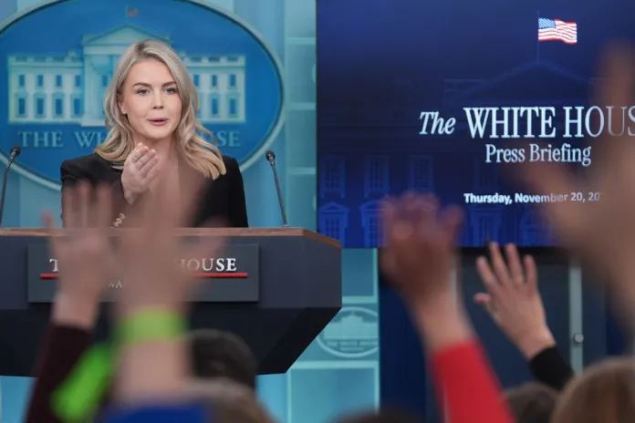 Reporters raise their hands to ask questions of White House press secretary Karoline Leavitt.