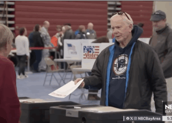 A voter hands in his ballot in a California election.
