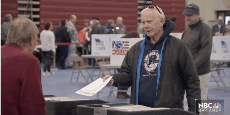 A voter hands in his ballot in a California election.