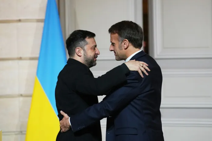 President Emmanuel Macron embraces Ukrainian President Volodymyr Zelensky