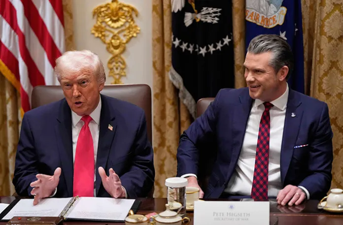 President Donald Trump speaks during a Cabinet meeting as War Secretary Pete Hegseth looks on at the White House.