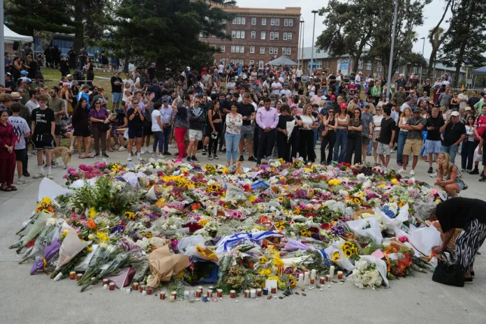 People gather around a tribute for shooting victims outside the Bondi Pavilion at Sydney's Bondi Beach.