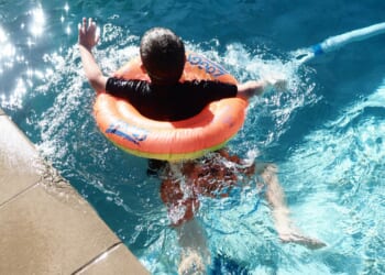 boy with floatie swims in pool
