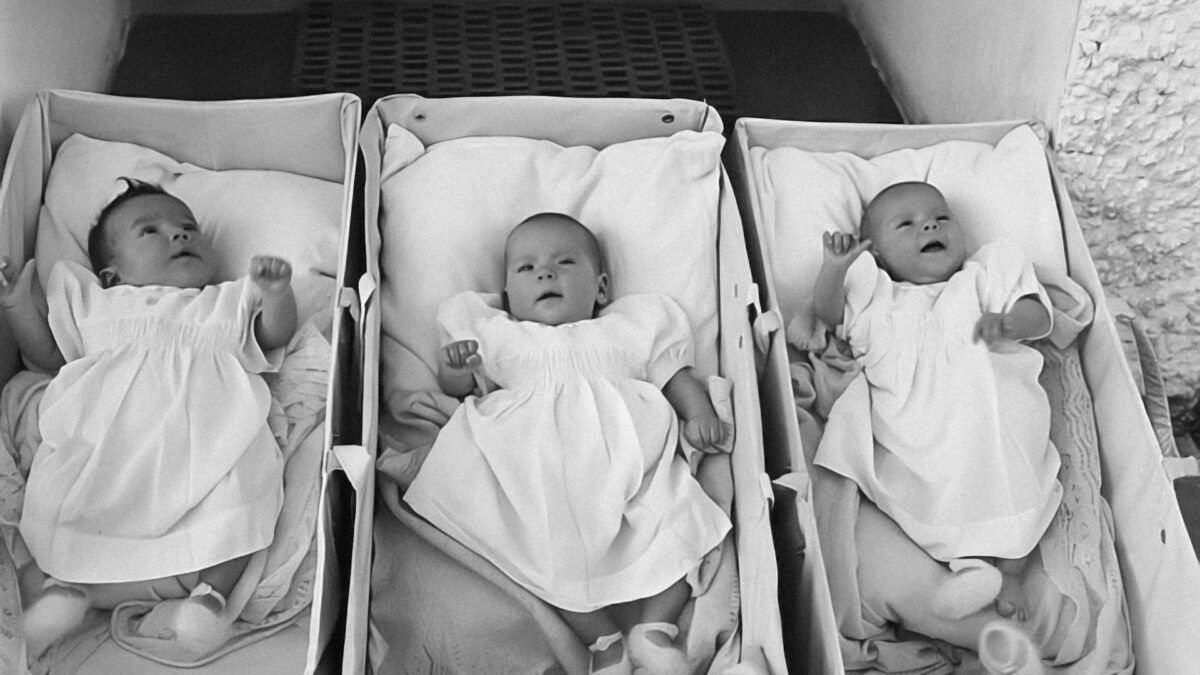 black and white photo of three triplet babies in hospital