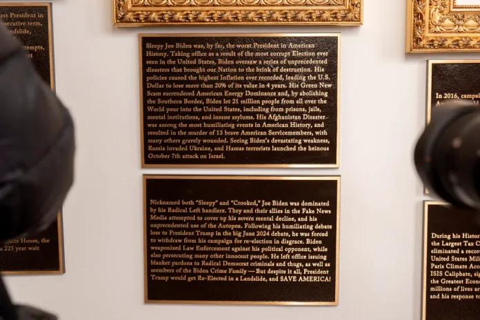 New plaques hang beneath a framed portrait of former President Joe Biden on the Presidential Walk of Fame at the White House.