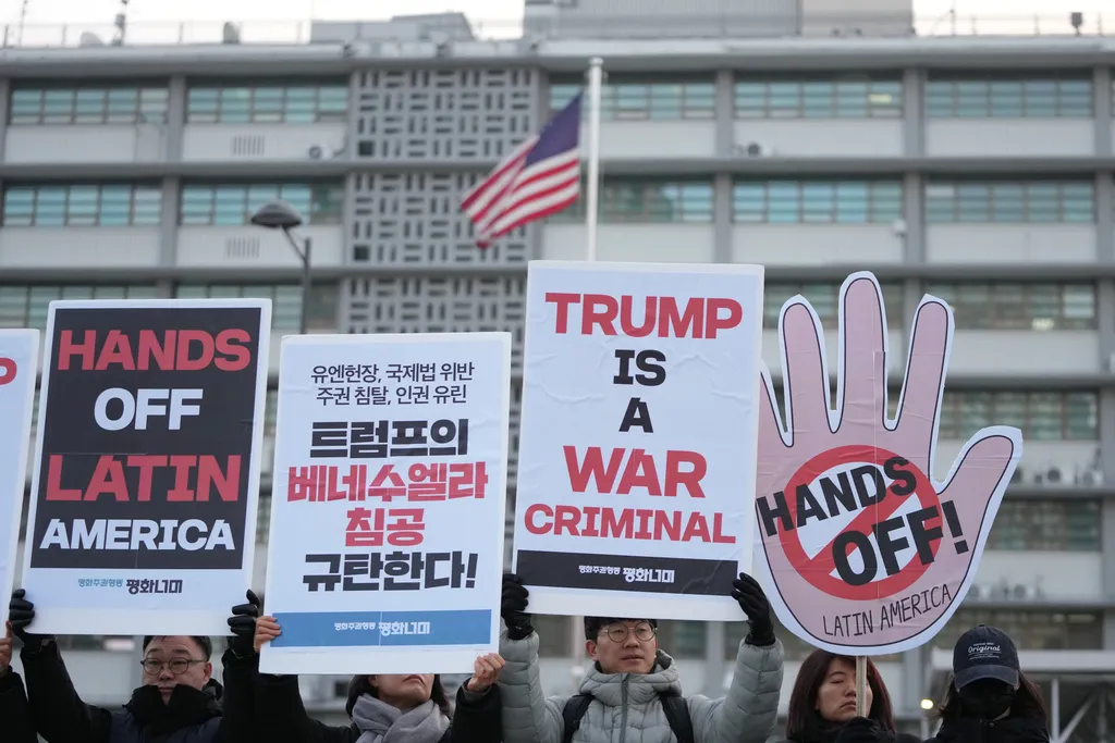 Protesters hold signs denouncing the U.S. military operation against Venezuela, near the U.S. Embassy in Seoul, South Korea, Wednesday, Jan. 7, 2026. (AP Photo/Lee Jin-man)