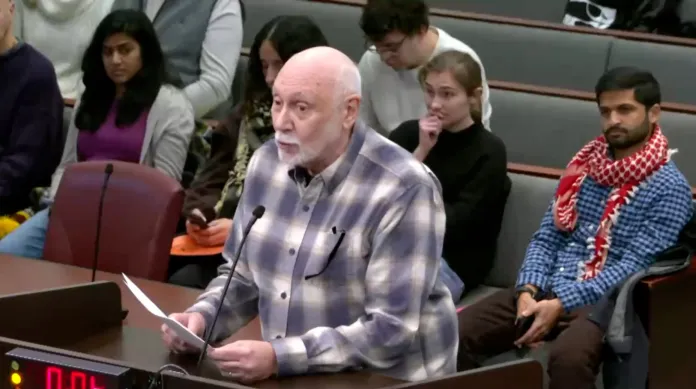 Man standing at podium talking into a microphone.