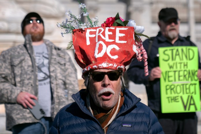 Protester wears "Free DC" hat.