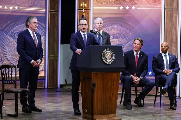 Doug Burgum, US secretary of the interior, from left, Josh Shapiro, governor of Pennsylvania, Chris Wright, US energy secretary, Glenn Youngkin, governor of Virginia, and Wes Moore, governor of Maryland, during an announcement in the South Court Auditorium of the Eisenhower Executive Office Building at the White House in Washington, DC, US, on Friday, Jan. 16, 2026. The Trump administration and several states laid out a plan intended to compel technology companies to effectively fund the construction of new power plants as a way to tame surging consumer utility bills while aiding the development of data centers.