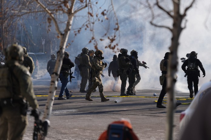 Federal immigration officers deploy tear gas at observers after a shooting Saturday, Jan. 24, 2026, in Minneapolis.
