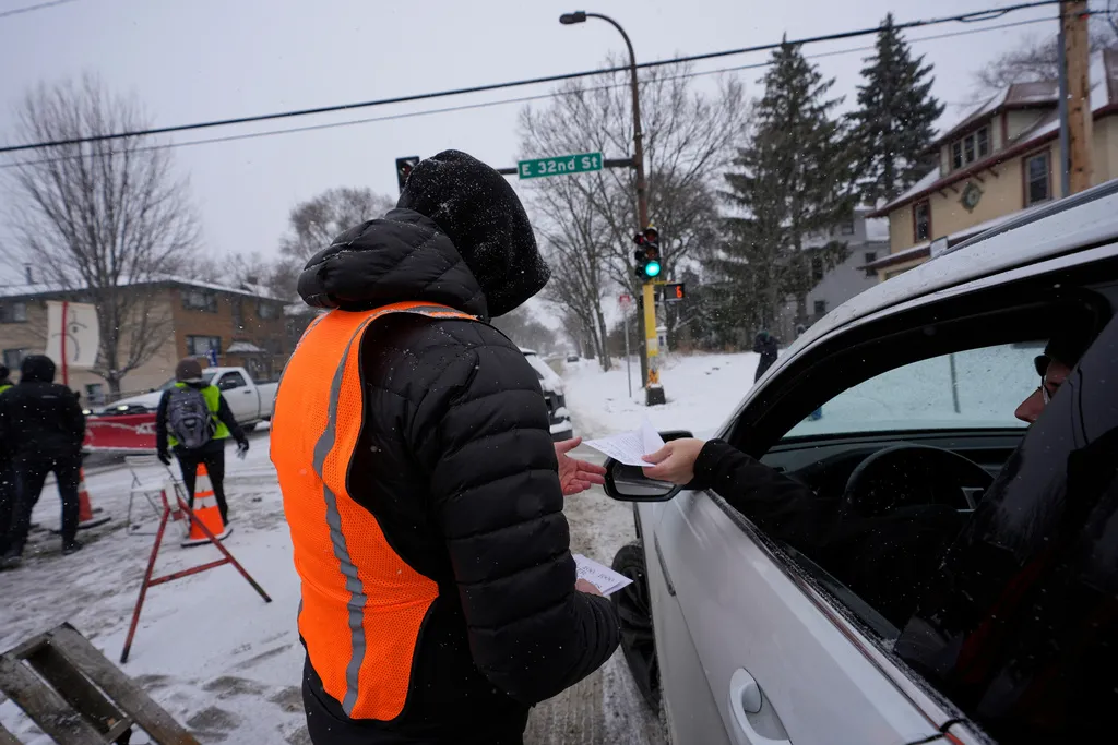 A motorist receives a flyer at a blockade set up to deter federal immigration enforcement vehicles in Minneapolis.