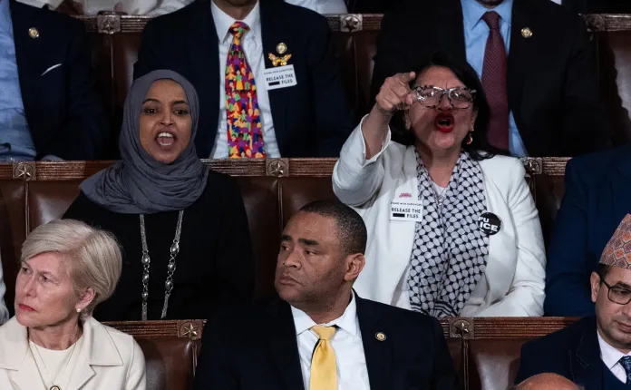 Rep. Ilhan Omar (D-MN) and Rep. Rashida Tlaib (D-MI) shout at U.S. President Donald Trump as he delivers his State of the Union address during a Joint Session of Congress at the U.S. Capitol on February 24, 2026, in Washington, DC.