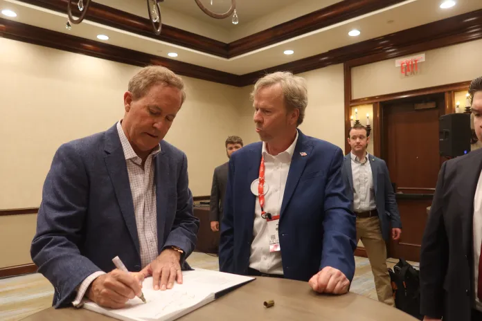 Attorney General Ken Paxton signs a book for a supporter at a meet and greet at CPAC on Saturday, March 28, 2026. (Samantha-Jo Roth, Washington Examiner)