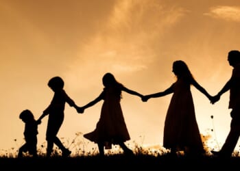 family silhouette against sunset