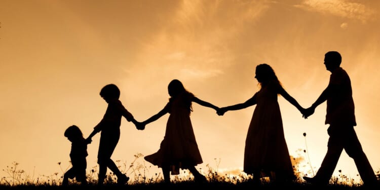 family silhouette against sunset