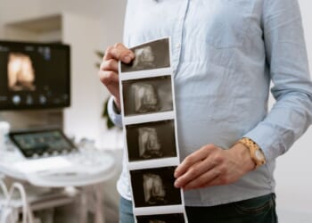 woman holding ultrasound photos